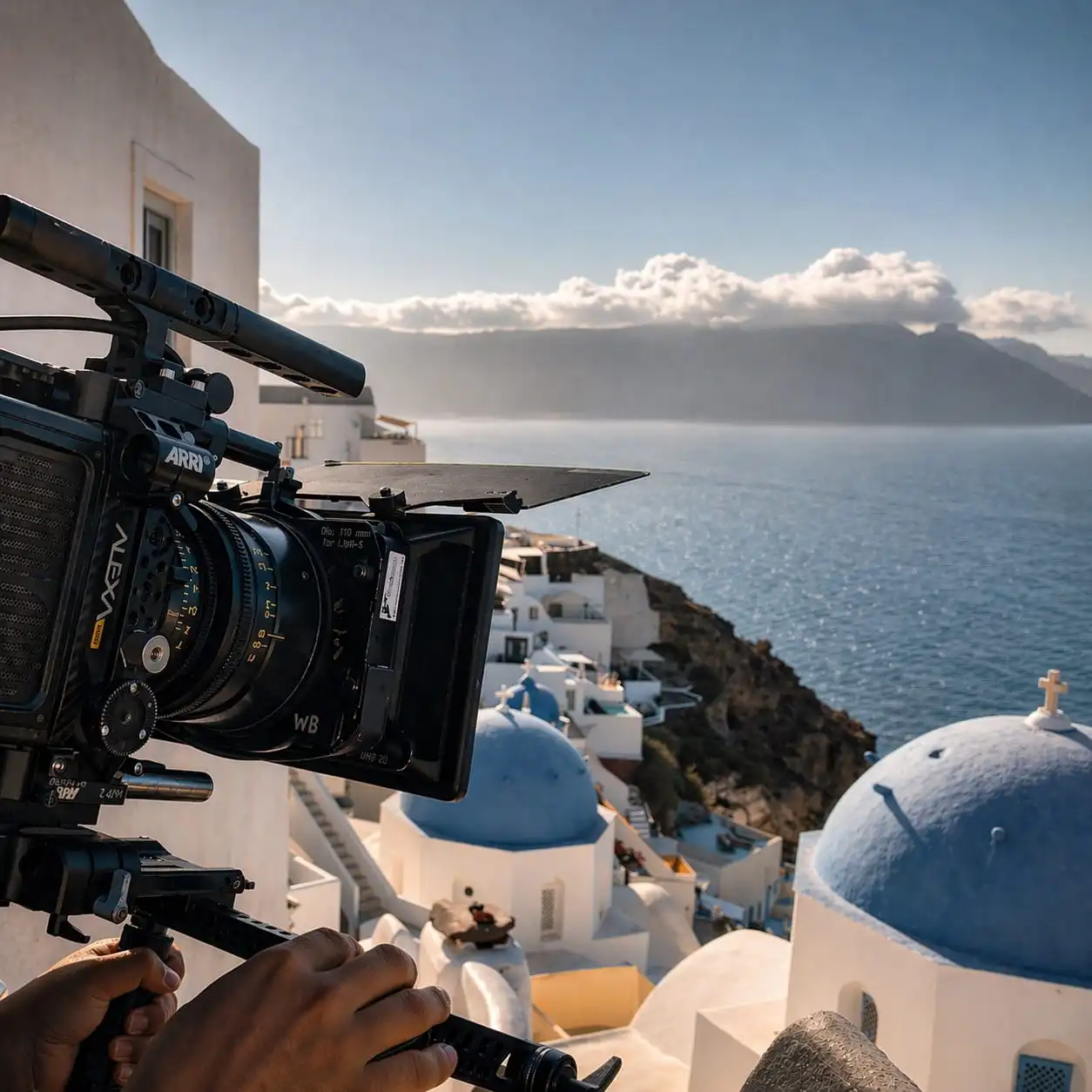 Camera filming above Santorini's white buildings and blue domes