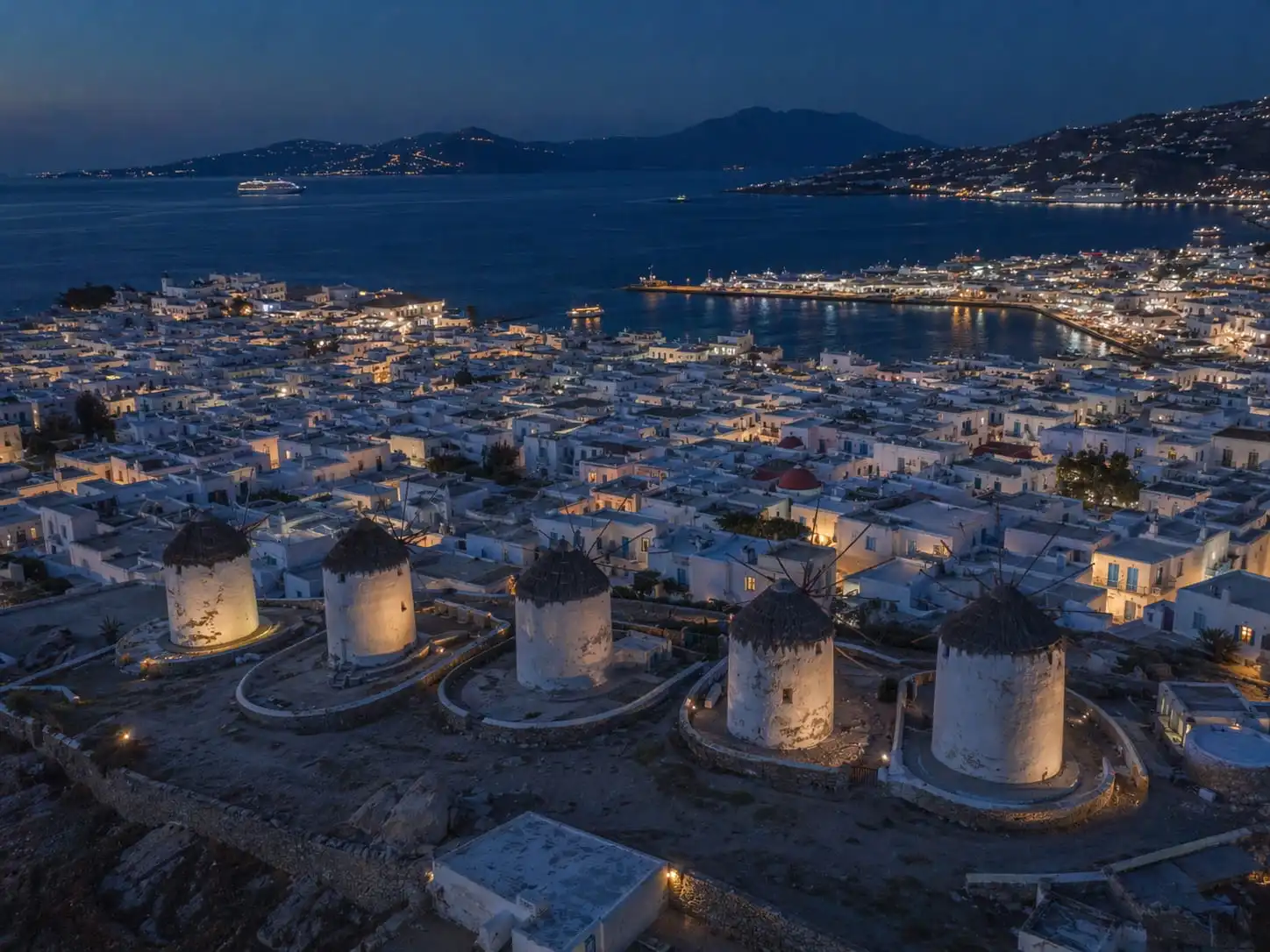 Mykonos windmills and town lights at dusk